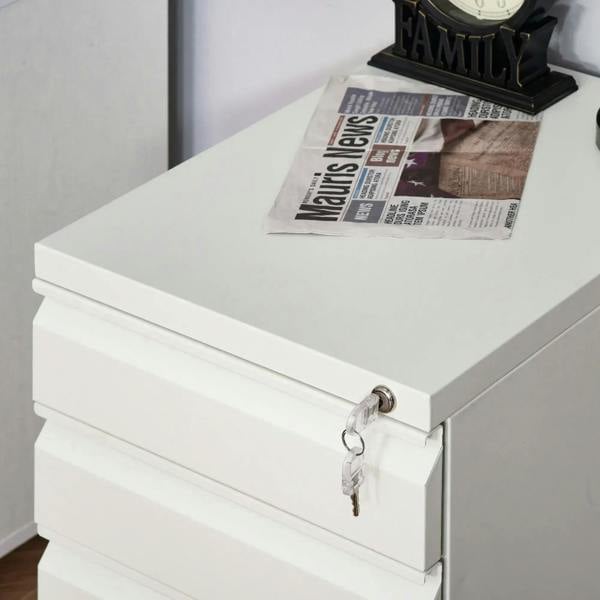 White metal filing cabinet top drawer with key lock and keys attached to the front.