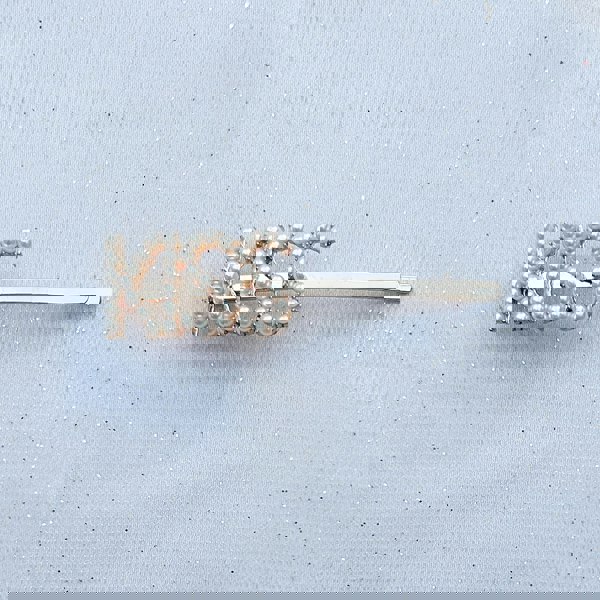 Gold hair slide with pearls spelling the word “KISS”
