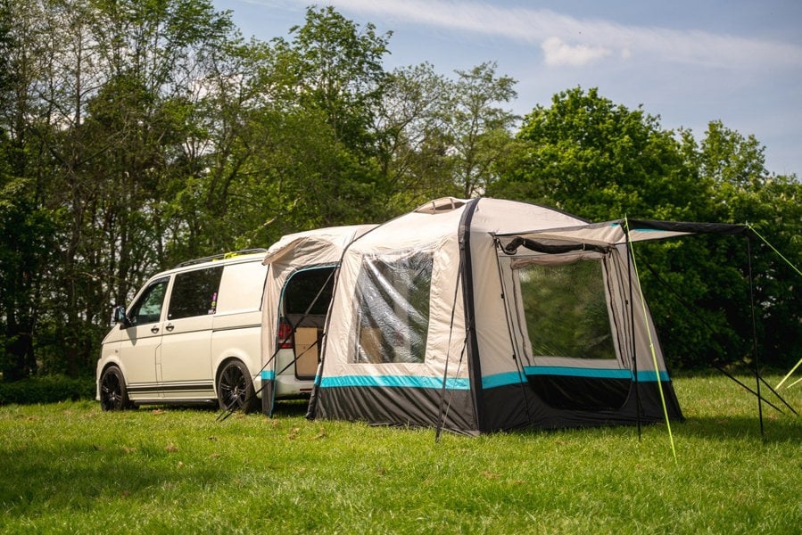 The OLPRO Snug Inflatable campervan Awning attached to the tailgate of a Volkswagen T5 camper, the doors of the awning are open & the canopy is up