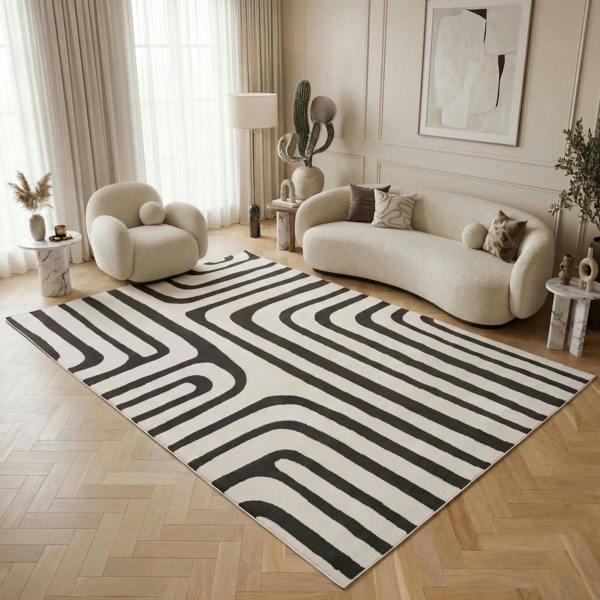 Living room with a black and white patterned rug, beige sofa, and armchair.