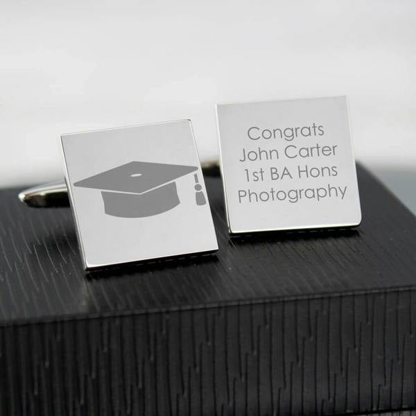 Personalised Square Graduation Cufflinks engraved with a graduation cap symbol on one cufflink and the text "Congrats John Carter 1st BA Hons Photography" on the other. Ideal university graduation gift.