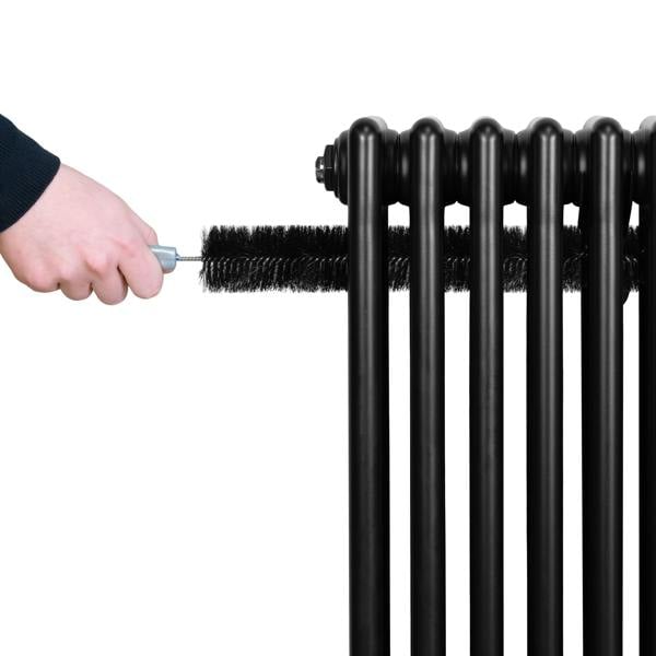 Traditional black 4 column radiator with a hand using a brush for cleaning, showcasing its sleek design and sturdy construction