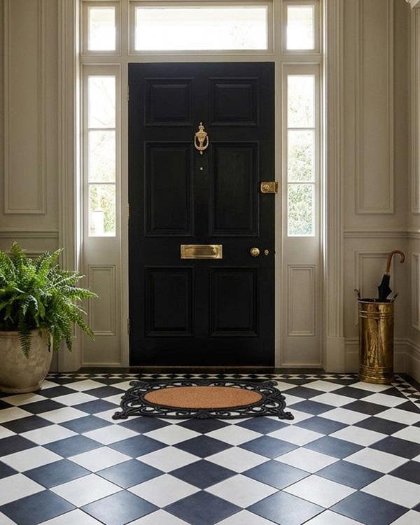 Stately entrance with black door, checkered floor, and decorative elements.