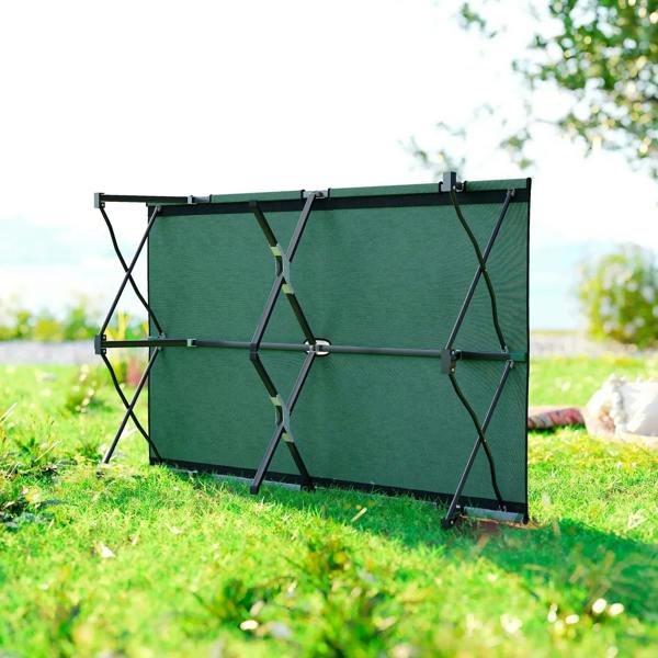 Green double camping cot bed fully expanded on grass