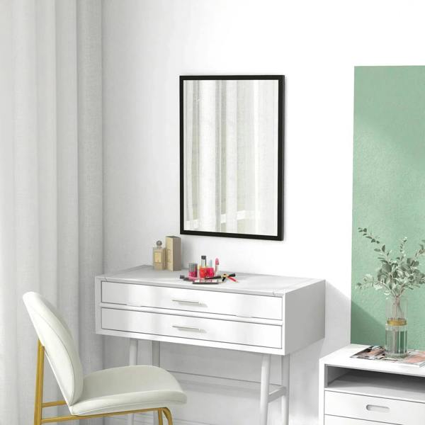 Rectangular black-framed wall mirror above a white vanity and striped curtain reflection