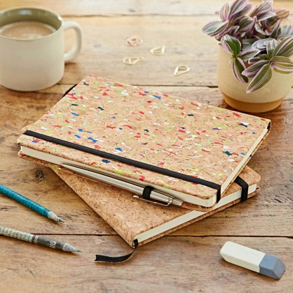 A Natural Cork A5 Notebook with a pen and pencil on a wooden table