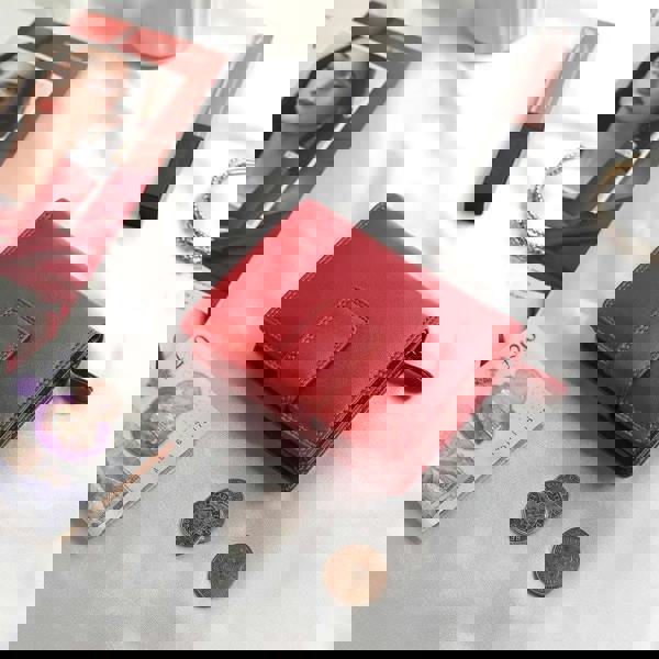 Soft red leather trifold purse with secure tab fastening – flat lay view