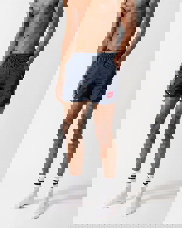 Model wearing a HUGO Dominica Mens Quick-Drying Swim Shorts In Recycled Material With Logo in Dark Blue
