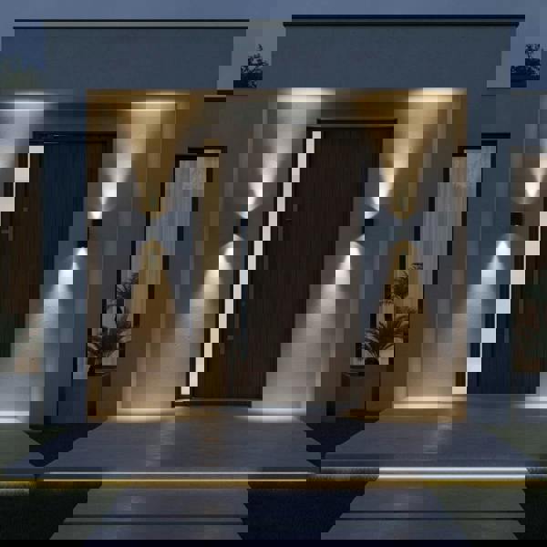 black outdoor up and down wall light mounted either side of the front door of a modern home with wooden front door