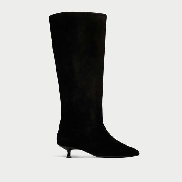 Black knee-high boot on a light gray background