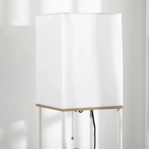 White fabric lampshade on a white frame with wood shelf trim
