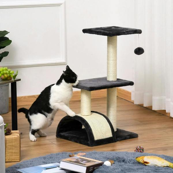 Black cat tree near wall with hanging ball, top perch, and arched scratching pad