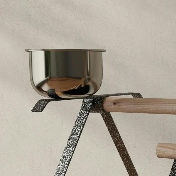 Stainless-steel bowl on black bird stand perch with textured metal legs
