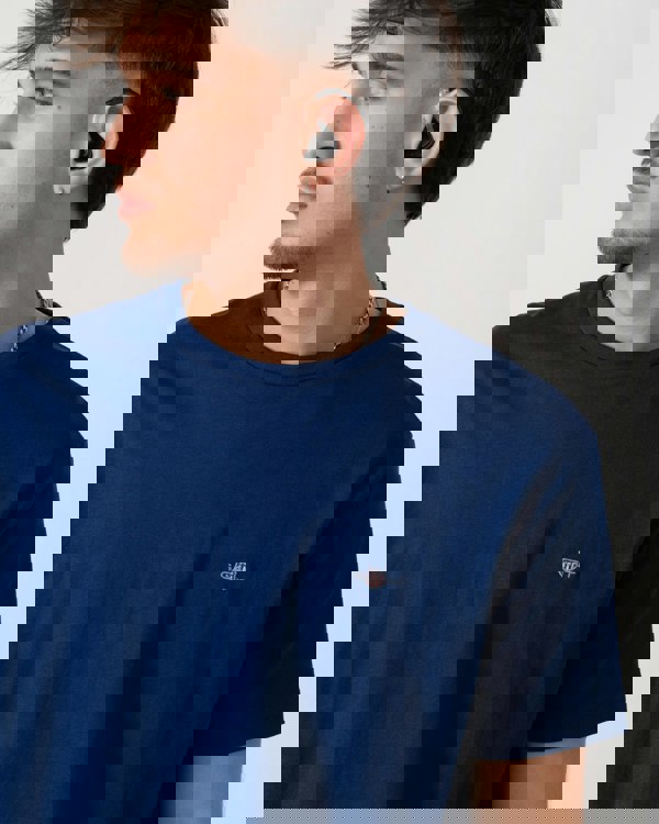 detail shot of a model wearing a GANT Mens Regular Fit Short Sleeve Shield Logo T-Shirt in Rich Navy