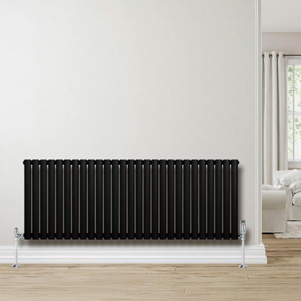 Sleek black oval single column radiator with chrome valves, mounted on a light wall, enhancing modern interior decor