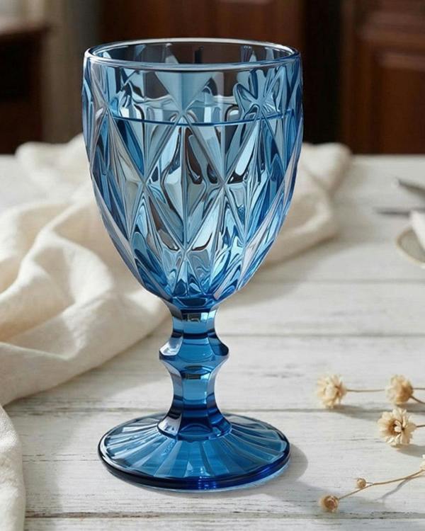 Blue glass goblet on a table with a neutral background