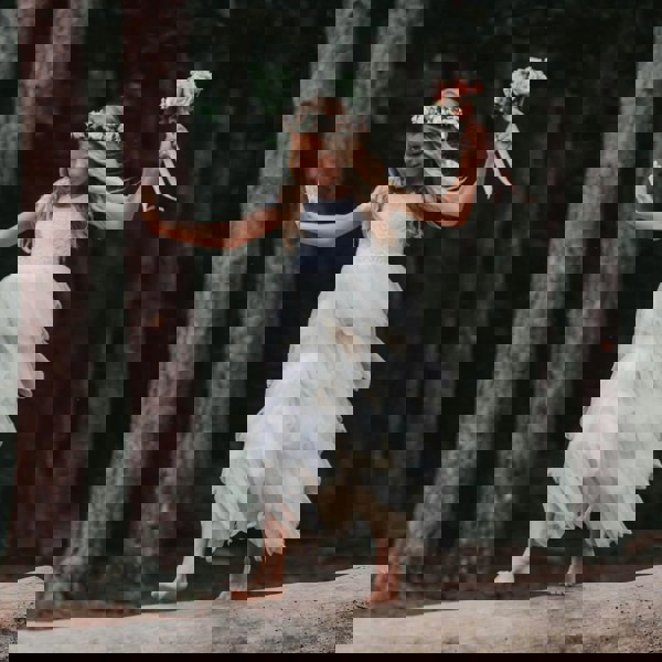 Girl holding bouquet and walking on log