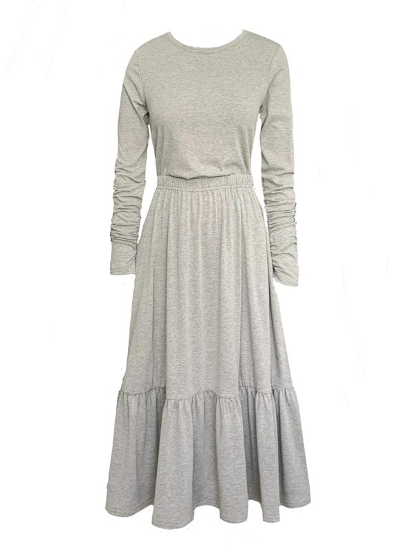 This is a boho style tiered midi length skirt with pockets paired with a grey long sleeve t-shirt with gathered sleeves.