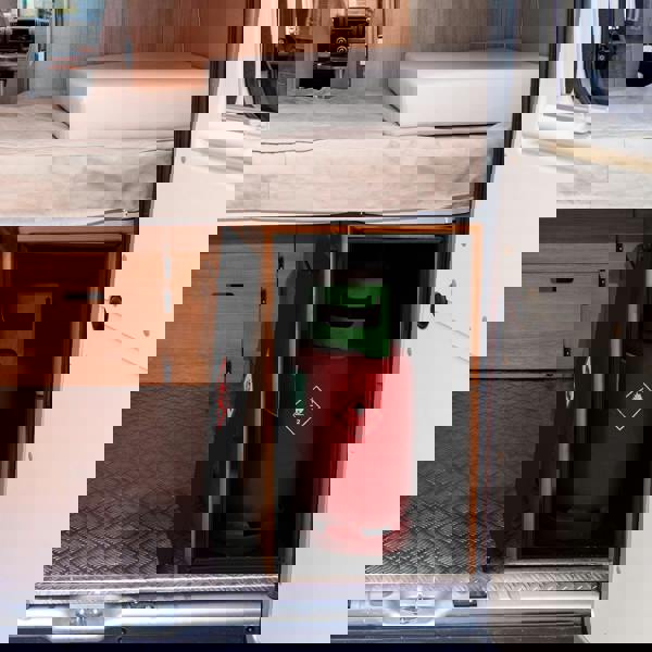 Compact black gas bottle locker securely holds a 6kg red gas bottle, designed for van interiors with wooden finishes and a textured floor