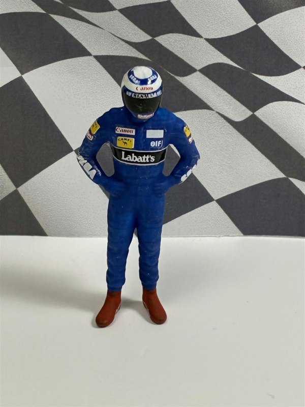 a toy figure of a man wearing a race suit