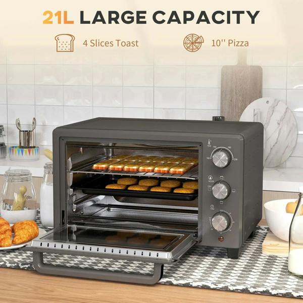 Grey mini countertop oven baking inside with trays and stacked bread-like food