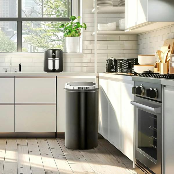 Stainless steel electric kettle on the floor in a modern kitchen near an oven