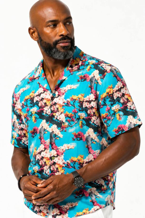 Man wearing a colorful floral shirt on a white background