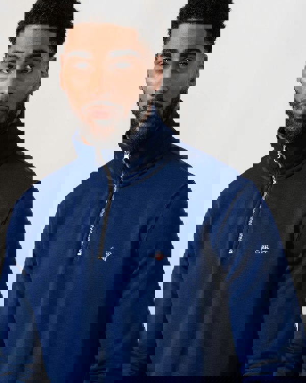 Model wearing GANT Mens Regular Fit Shield Logo Half Zip Sweatshirt in 432 Rich Navy - Detail