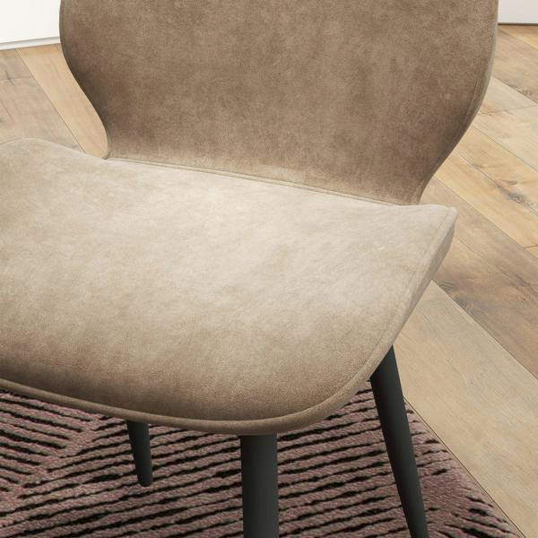 Close-up of a light brown velvet dining chair seat with black legs