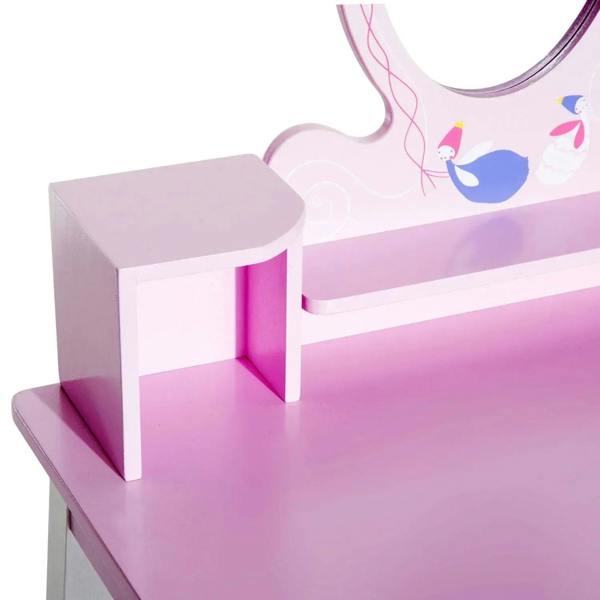 Pink wooden cubby storage and tabletop on a kids dressing table beneath the mirror