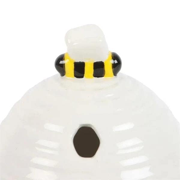 White bee-hive incense cone holder close-up with yellow-black striped collar and front opening