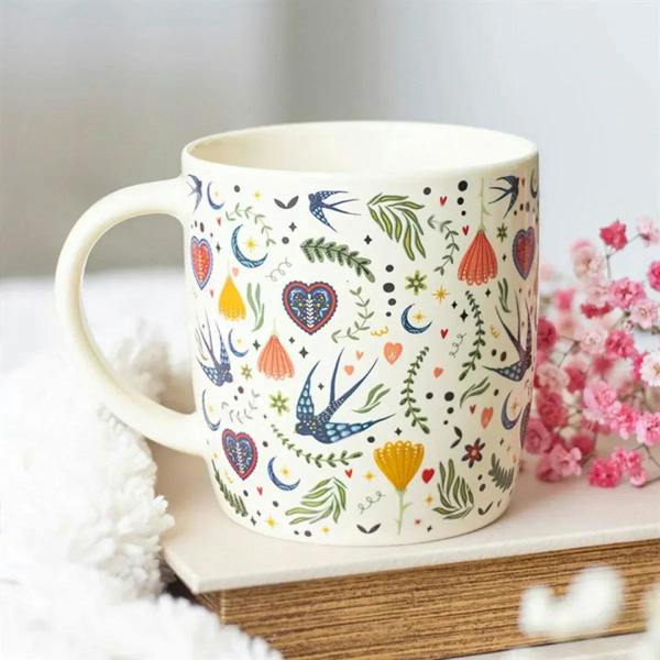 Cream mug with colorful floral bird and heart pattern