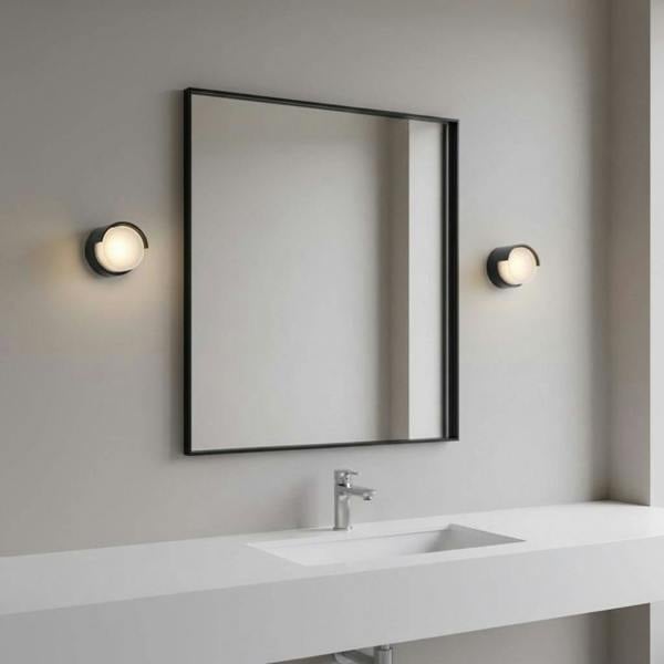 black bathroom wall light fixture mounted either side of a mirror in a modern bathroom