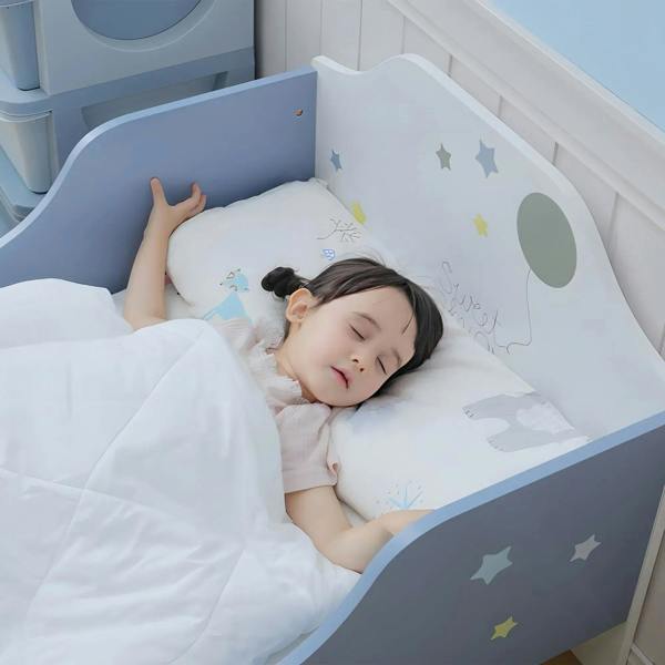 Toddler in bed on a blue and white frame with curved guardrail and star decals