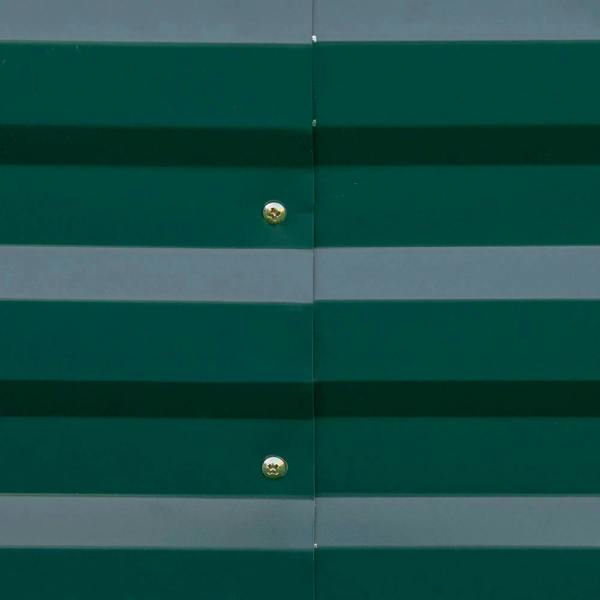Green metal raised garden bed wall panel with visible corner seam and screws