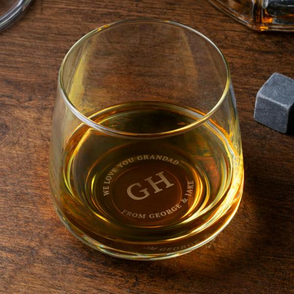 Glass whisky tumbler viewed from above showing custom base engraving that reads 'GH - WE LOVE YOU GRANDAD FROM GEORGE & JAKE'.