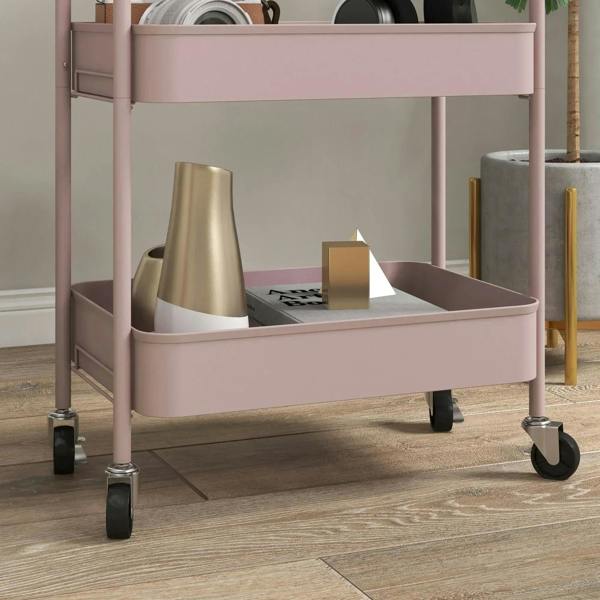 Pink three-tier steel storage trolley with lower shelf and four caster wheels; front angle