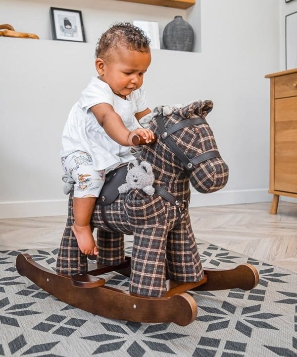 Little girl playing on rufus and ted rocking horse