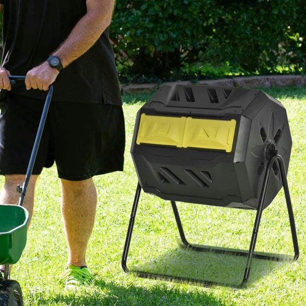 Yellow and dark gray rotating composter with two front legs, outdoor standing view