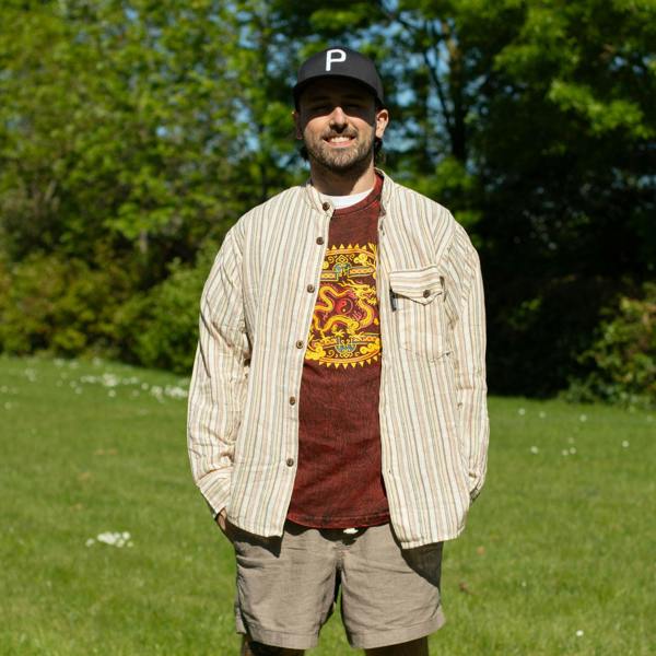 Maroon crew-neck t-shirt with yellow dragon mandala graphic, worn by man in outdoors