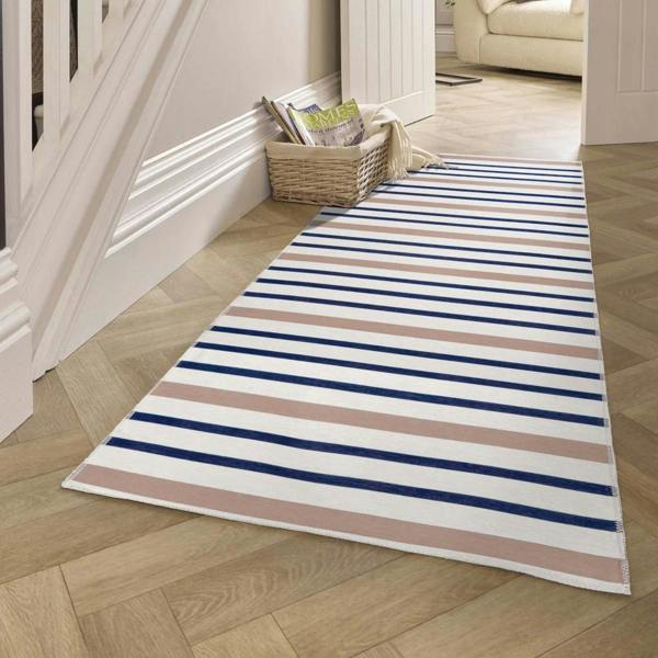 Striped rug on a wooden floor with a staircase and basket in the background