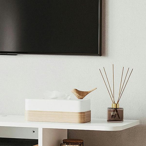 White floating TV console shelf with decorative items and open storage beneath