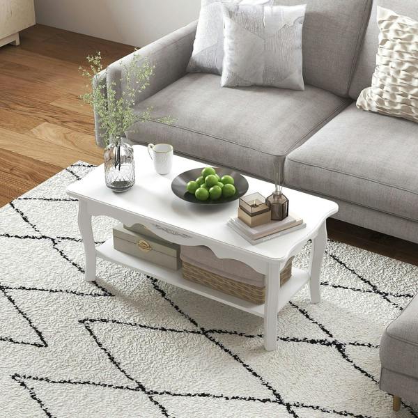 White rectangular coffee table with two drawers and bottom shelf, decorated with tabletop items