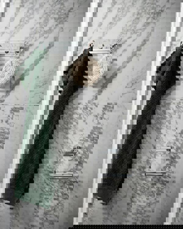 Polished chrome triple towel hook on bathroom wall