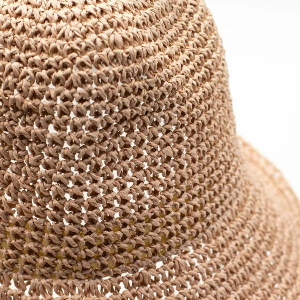 Close-up of woven rose blush straw texture on the wide hat brim