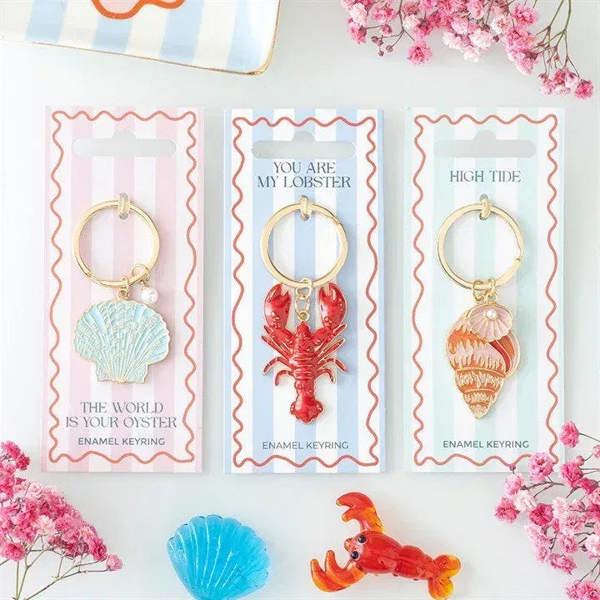 Assorted ocean-themed enamel keyrings with seashell, lobster, and crab charms