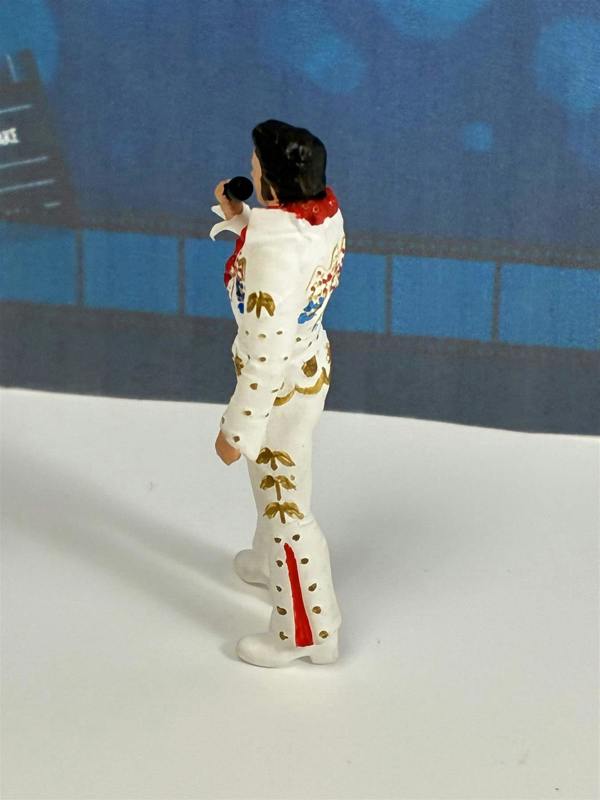 a toy figurine of a man holding a microphone