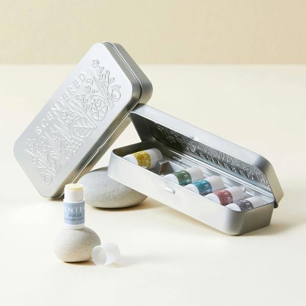 Silver tin with design containing mini balms and another tin on a light background