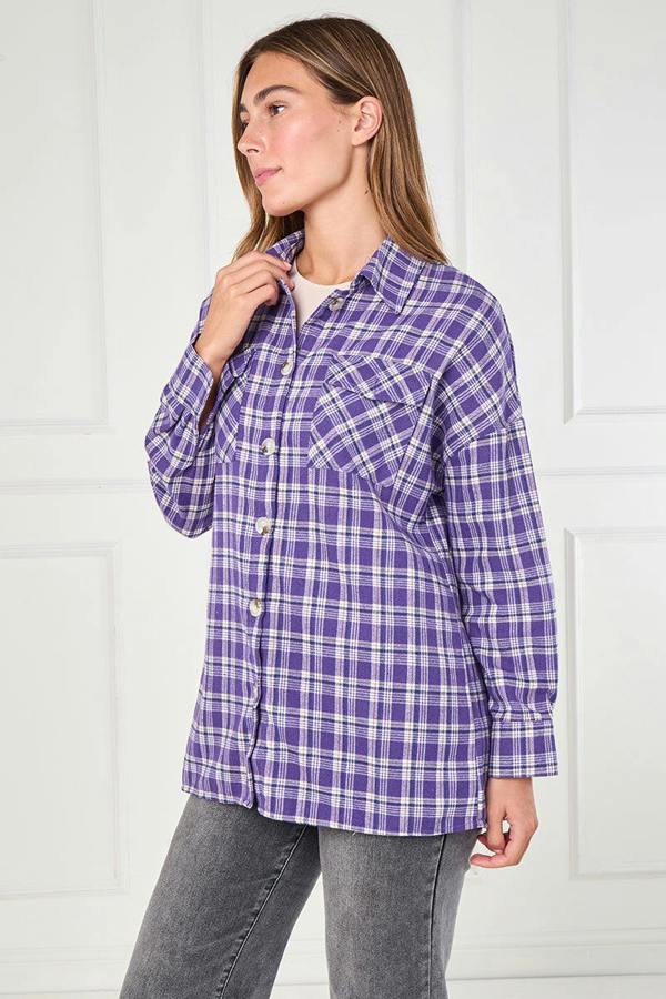 Woman wearing a purple plaid shirt against a white background