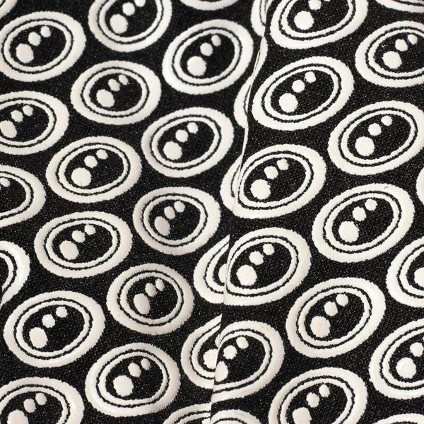 Extreme close-up of black Optimum Stik Mits glove fabric showing raised white oval silicone grip print - Optimum